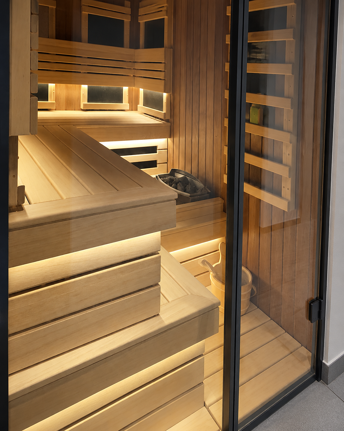Moderna kombinovana finska i infracrvena sauna od termičkog aspena i abasi drveta sa staklenim vratima u aluminijumskom profilu, izgrađena u privatnom wellnessu u Crnoj Gori.